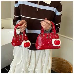 Detailansicht roter Polka-Dot-Muscheltaschen in zwei Größen mit Apfel-Plüsch-Anhänger