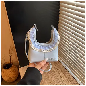 Close-up of light blue shoulder bag featuring delicate white lace trim and floral ruffles