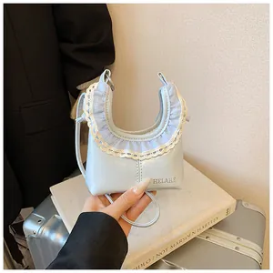 Detail of light blue crescent bag with pleated gingham edges and delicate white lace trim