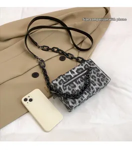 Leopard print crossbody bag with black chain strap shown next to a phone for scale