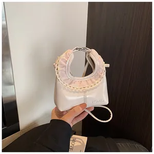 Detailed view of cream tote bag featuring pink checkered lace trim and embossed logo