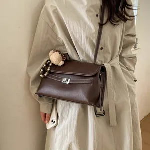 Dettaglio della borsa vintage marrone con cuciture a contrasto e chiusura a girello argento