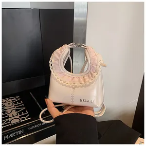 Detail of cream glossy leather handbag with pink plaid fabric and lace trim decoration