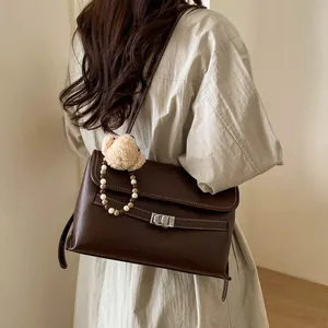 Dettaglio della borsa tote marrone vintage con chiusura argento e charm orso