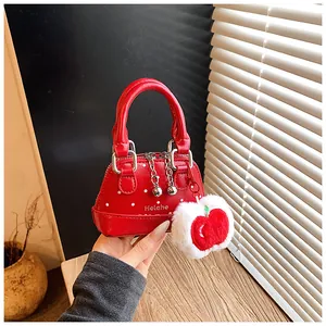 Macro detail of red polka dot shell bag featuring dual metal zip pulls and apple charm