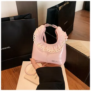 Detail of pink glossy shoulder bag with lace trim and silver HELEHE logo print