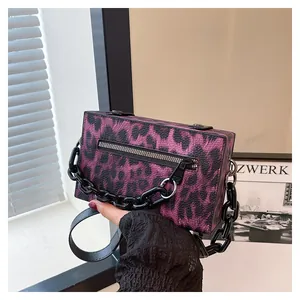 Close-up of purple leopard print box clutch bag with thick black chain and zipper detail