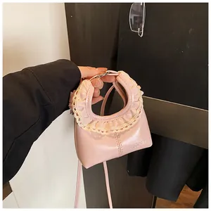 Detailed close-up of pink shiny PU leather bag featuring elegant beige lace-trimmed handle