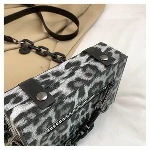 Detail of leopard print bag showing textured finish and black chain leather strap