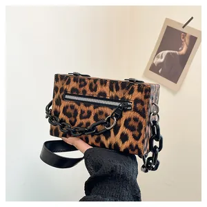 Detail of leopard print fabric texture and silver zipper on the mini crossbody bag