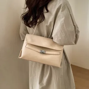 Modella che indossa una borsa a tracolla beige vintage con fibbia in metallo e pelle morbida
