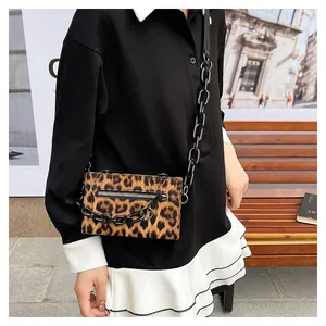 Close-up of leopard print crossbody bag with black acrylic chain and stylish zipper detail