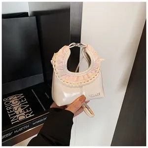 Detail of a mini cream white handbag with pink plaid ruffles and white lace edging
