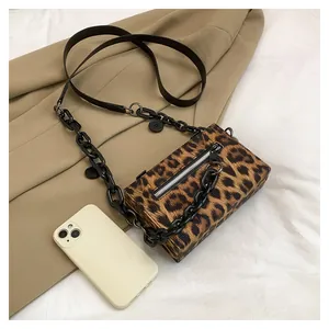 Macro shot of leopard print handbag with silver zipper and black chain strap details