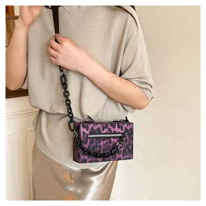 Detail of purple leopard box bag with thick black chain strap and silver zipper accents
