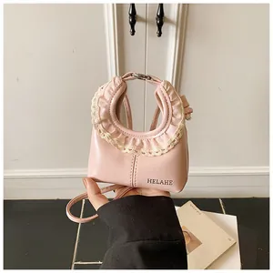 Close-up of pink leather tote bag featuring elegant cream lace trim and brand logo
