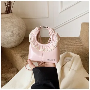 Close-up of pink leather tote with lace trim detail and HELAHE branding logo
