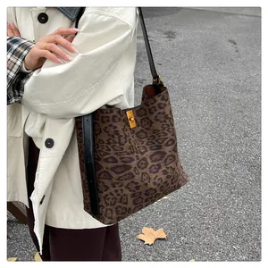 Dettaglio di borsa tote leopardata con chiusura in metallo dorato e tracolla in pelle