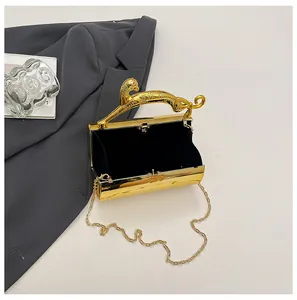 Detailed view of luxury gold metal clutch bag with leopard handle on grey suit background