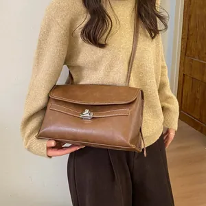 Dettaglio della borsa vintage marrone con fibbia in metallo argento e cuciture a contrasto