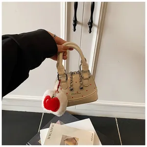 Mini cream patent leather handbag with red polka dots and plush apple charm accessory