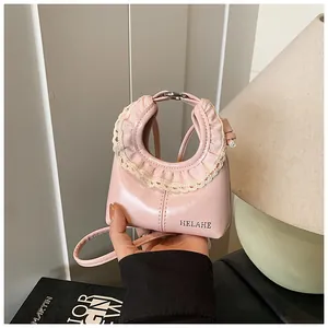 Detail of light pink shoulder bag featuring elegant beige lace ruffles and brand logo