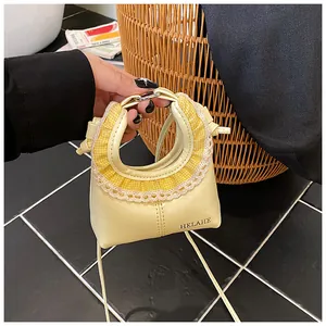 Detail of light yellow mini bag featuring lace trim and a unique round hole handle