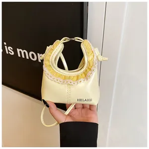 Detail of cream yellow leather tote with lace trim and HELAHE branding text