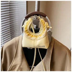 Detail of yellow tote with lace trim and check pleats on a stylish shoulder bag