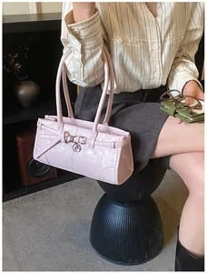Macro detail of glossy pink leather shoulder bag with silver ring buckle and strap