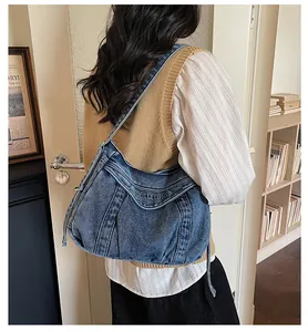 Détail du sac fourre-tout en denim bleu vintage avec broderie et décor à franges