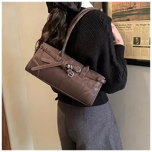 Detailed view of a dark brown retro shoulder bag with unique strap buckle decorations