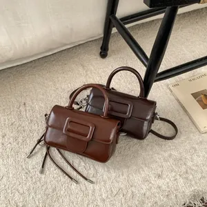 Close-up of retro square handbags in reddish brown and dark coffee with glossy leather
