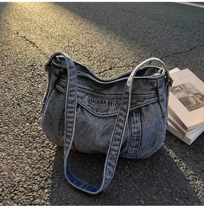 Vue macro d'un sac hobo en jean délavé avec broderie vintage et texture souple