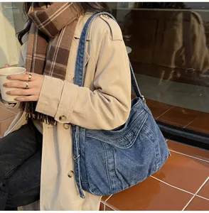 Gros plan détaillé d'un sac cabas en denim bleu foncé avec broderie BELETING grise