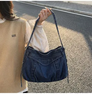 Gros plan du sac fourre-tout en denim bleu délavé avec broderie SUBELETING foncée