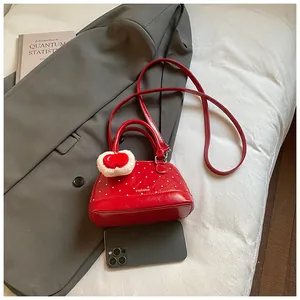 Mini red polka dot shell bag with plush heart charm and crossbody strap