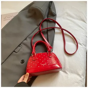 Detail of red shell handbag with white polka dots and glossy patent leather finish