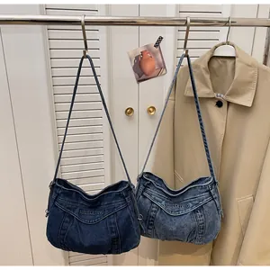 Détail de sacs hobo en denim bleu avec broderie Subeleting et boucles en métal sur sangle