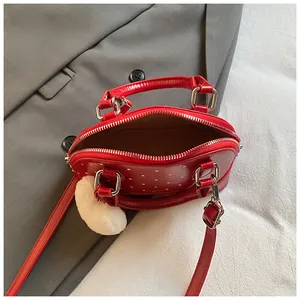 Top view of mini red polka dot shell bag showing silver zipper and brown fabric lining