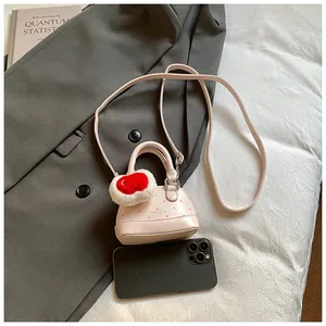 Mini pink shell bag with heart charm and smartphone for size reference
