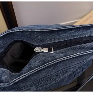 Détail du sac en jean avec fermeture à glissière en métal argenté et doublure intérieure