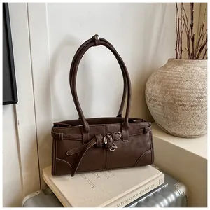 Close-up of brown matte leather bag featuring vintage strap decor and metal eyelets