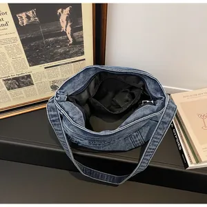 Vue détaillée du sac en jean montrant la doublure, la poche zippée et l'espace de rangement