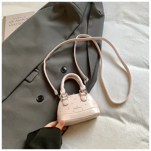Close-up of pink mini crossbody bag with dot pattern and delicate metal buckle detail
