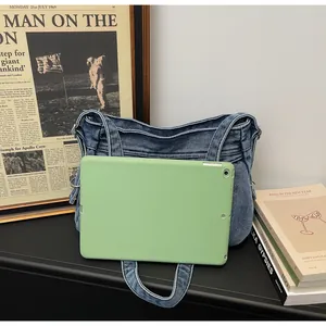 Détail du sac cabas en denim bleu montrant sa capacité avec une tablette à l'intérieur