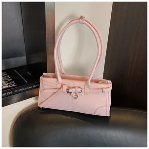 Detail of pink faux leather shoulder bag with decorative buckle and silver metal ring