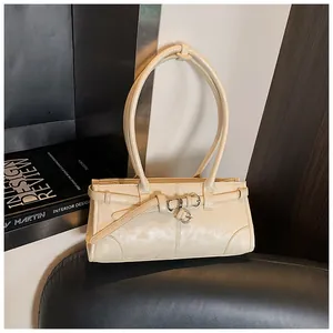 Close-up of cream textured faux leather handbag with elegant silver ring hardware
