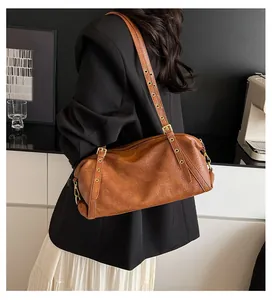 Detail view of the brown Boston bag with adjustable leather strap and matte gold hardware