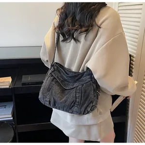 Détail du sac bandoulière en denim noir délavé avec broderie SUBELETI et texture plissée